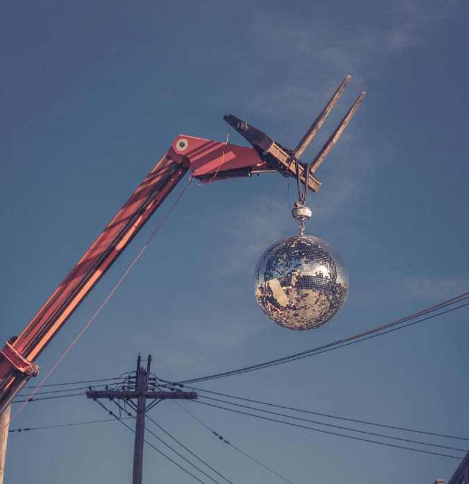 Glitter ball hangs from the fork of a forklift truck